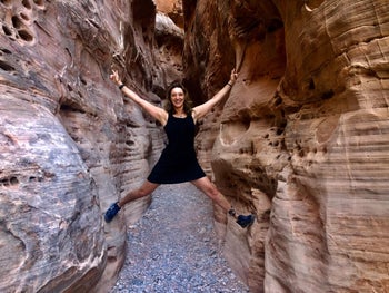 A reviewer wearing the dress while stretching out their arms and legs to mount a cavern 