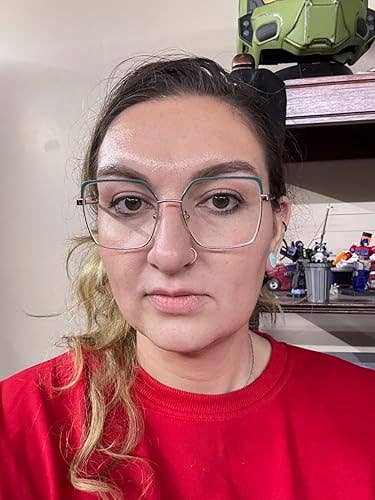 reviewer wearing glasses and a reddish  top, lasting  successful  a decorated room