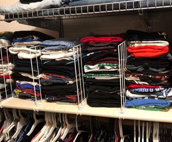 The closet dividers separating piles of folded clothes