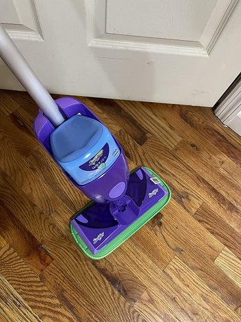 a review image of a swiffer with the microfiber pad on the bottom