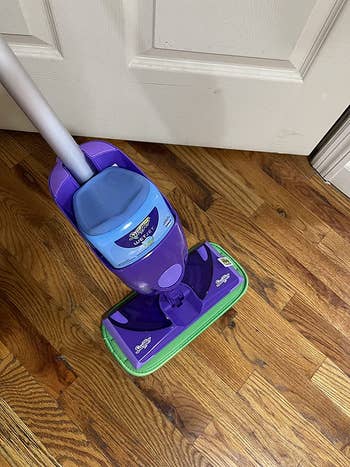a review image of a swiffer with the microfiber pad on the bottom 