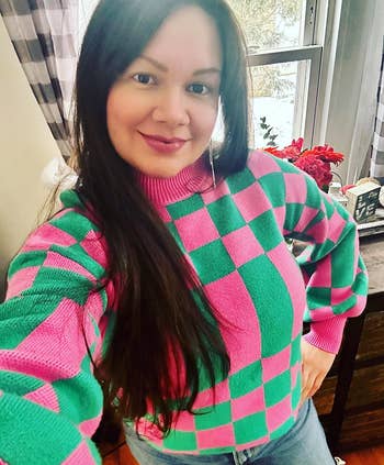 A reviewer wearing the pink and green sweater