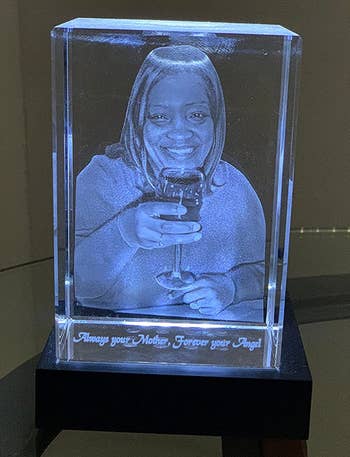 a reviewer photo of the crystal block etched with a photo sitting on an illuminated base 