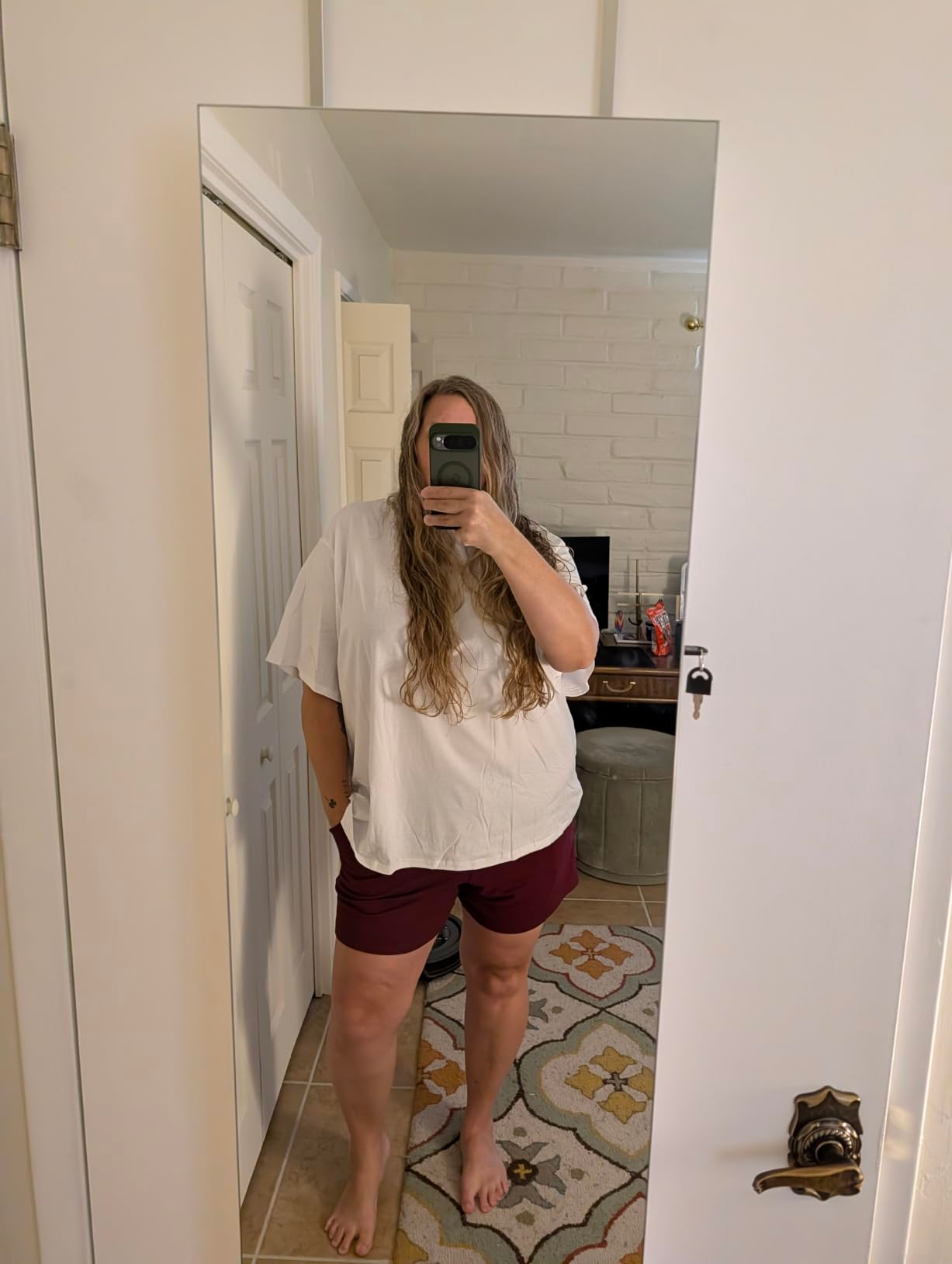 Person taking a reflector  selfie wearing a escaped   achromatic  apical  and shorts, lasting  successful  a country   with a rug and disposable   door