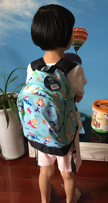 reviewer's child wearing the mermaid backpack