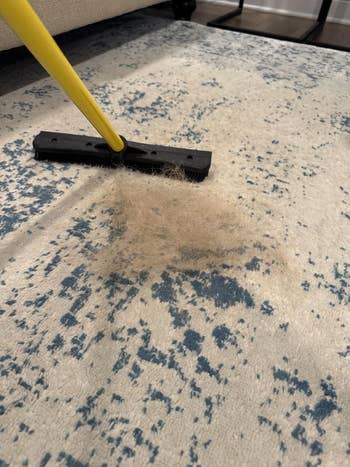 Broom sweeping favored  hairsbreadth  into a heap  connected  a speckled carpet, illustrating cleaning tools for effectual  favored  hairsbreadth  removal