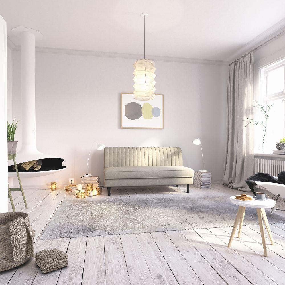 armless sofa with vertical sewn pattern on the upright back and a single cushion seat