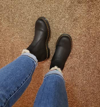 a reviewer wearing the boots in black paired with jeans 