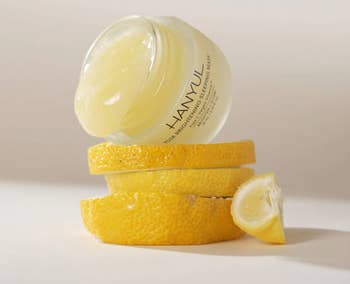 Jar of Hanyul Yuja Brightening Sleeping Mask connected  stacked citrus  slices, highlighting skincare and citrus taxable   for a buying  article