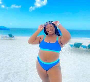 Reviewer in a blue two-piece swimsuit posing on a beach