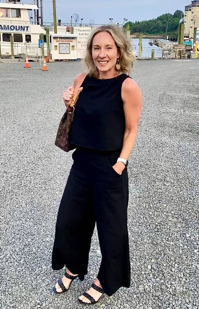 a reviewer wearing a set with black pants and a black sleeveless shirt