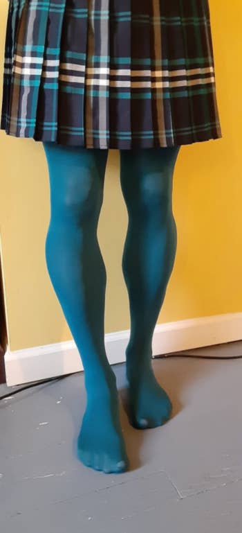 another reviewer in teal blue tights with plaid skirt