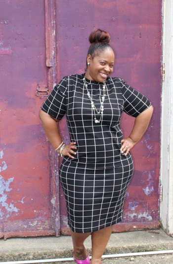 Reviewer wearing black and white checkered midi dress with pinkish-purple shoes