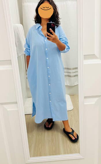 reviewer in long blue shirt dress and black sandals