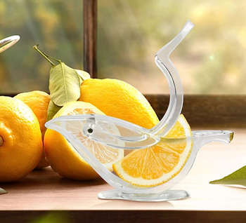 A clear acrylic bird shaped squeezer with an orange slice in it 