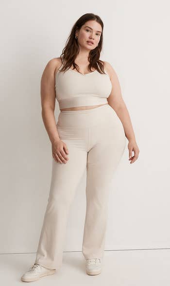 A model posing in the cream colored pants