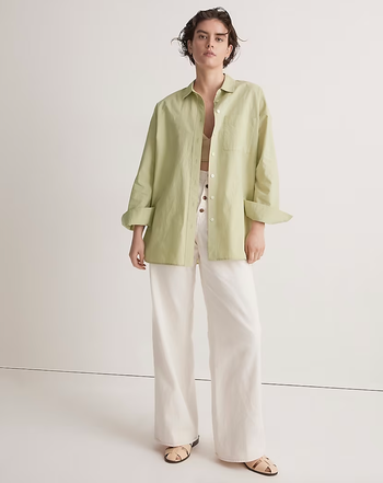 Model in oversized button up pale green collared shirt 