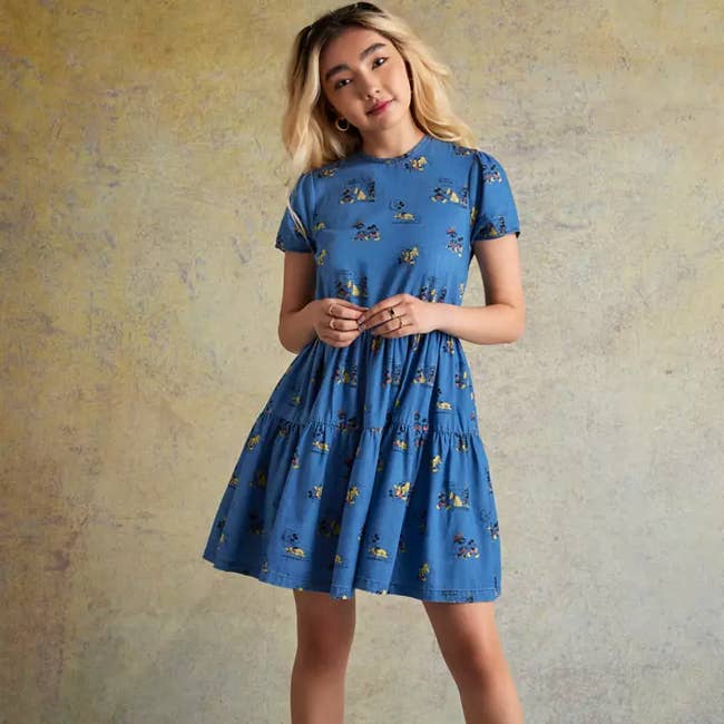 a model in a chambray dress with mickey cartoons on it 