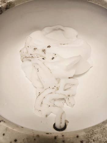 Shaving cream-like foam successful  a descend  with a fewer  specks of dirt