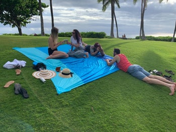 reviewer using the blanket on grass