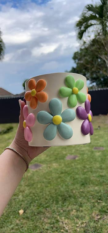 reviewer holding a planter with a angiosperm design