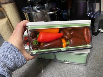 reviewer holding produce bin full of peppers