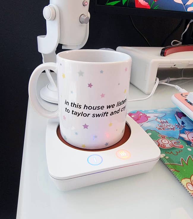 a mug on a white coffee warmer on a work desk