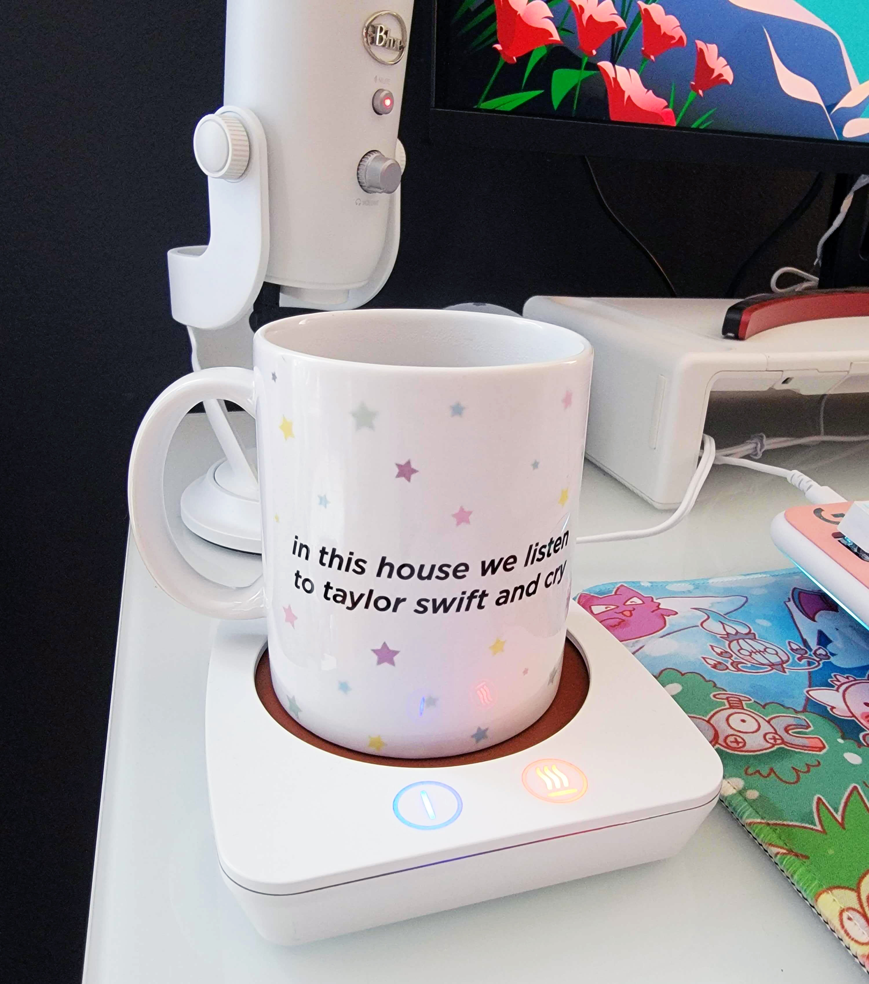 a mug on a white coffee warmer on a work desk