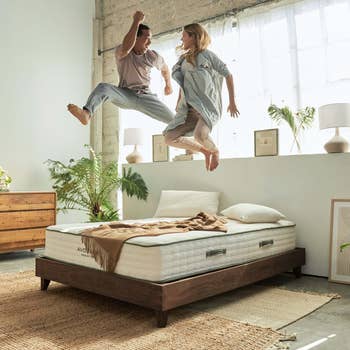 couple jumping on Avocado Green Mattress on City Bed Frame