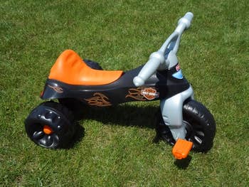 Reviewer's image of black, orange, and gray tricycle 