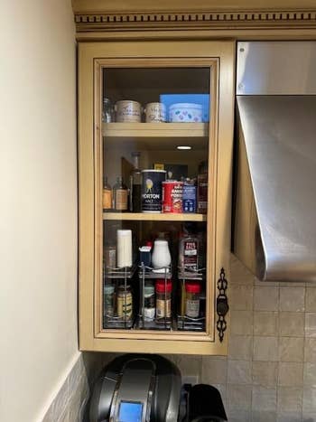 same cabinet filled with three spice racks with door closed