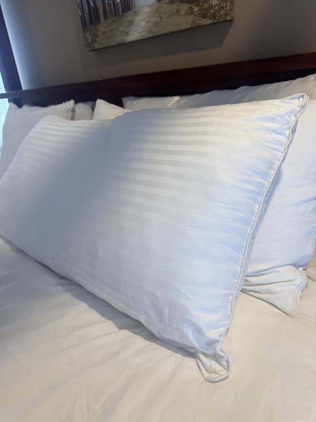 Plush pillow on a neatly made bed, showcasing a striped texture suitable for home decor or bedding shopping