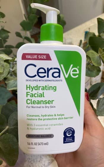 A manus  holding a vessel  of CeraVe Hydrating Facial Cleanser for mean   to adust  skin, worth  size. The merchandise  is 16 fluid ounces (473 mL)