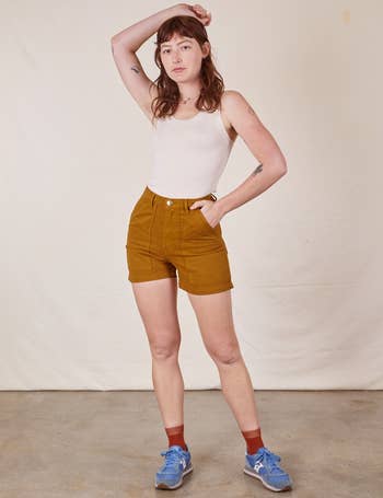 model in the mustard colored shorts