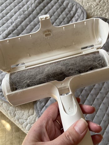 reviewer shows the inside of a used roller full of hair