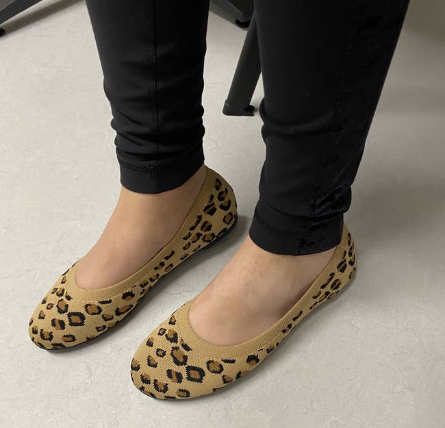 Person wearing leopard people flats with achromatic pants