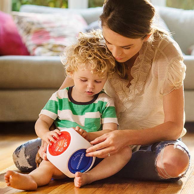 A model and child playing with the musical cube