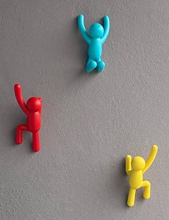 reviewer photo of the colorful wall hooks on a wall