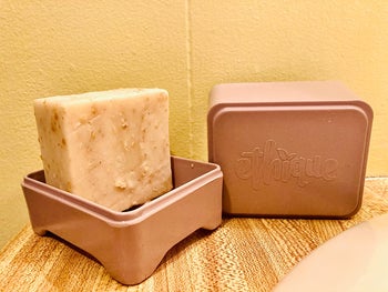 Reviewer's bar of soap sitting in a soap container 