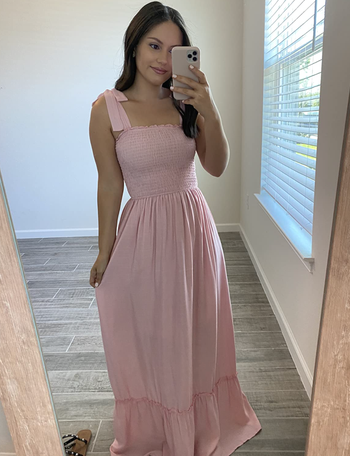 Reviewer wearing light pink tiered maxi dress with tie sleeves