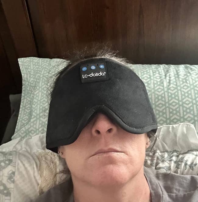 a reviewer wearing the black Bluetooth sleep mask