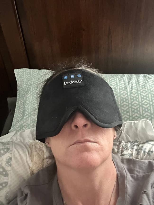 a reviewer wearing the black Bluetooth sleep mask