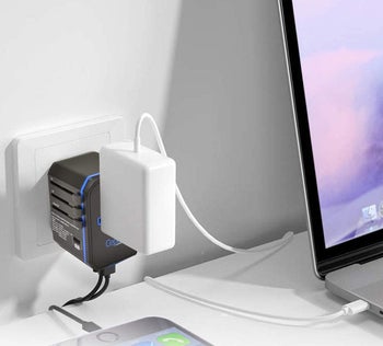 The black charger with USB cords and a large charger coming out of it