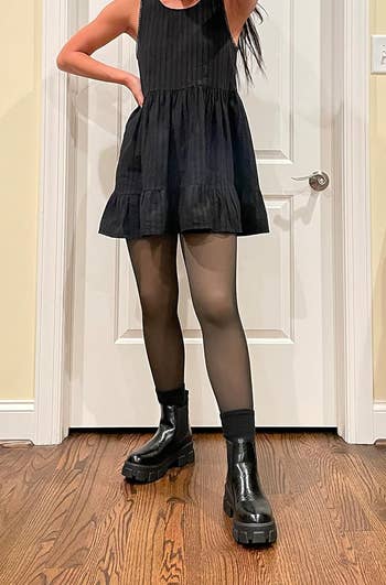 reviewer wearing the chunky boots with a mini dress and tights