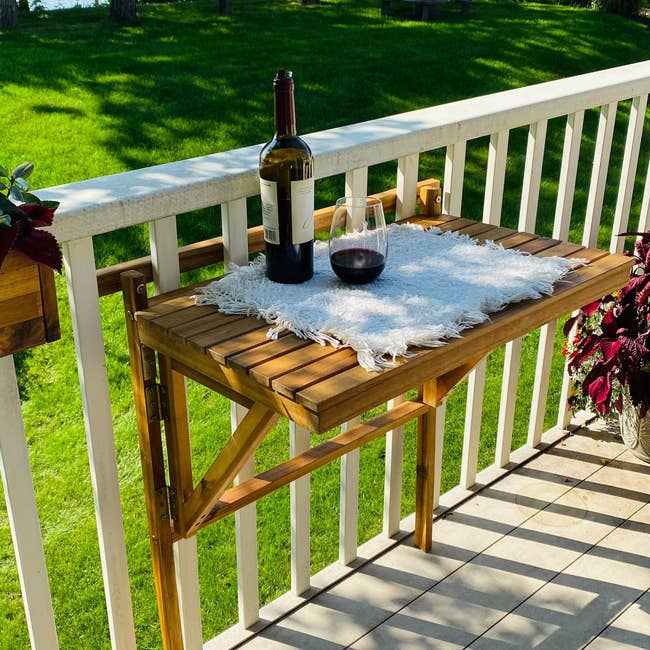folding wooden table attached to balcony bars