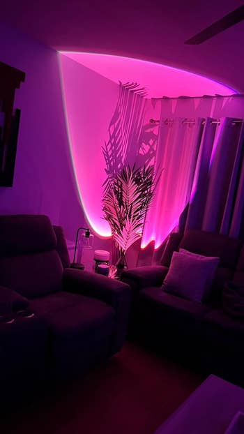 Living room with purple sunset lighting cast on the wall