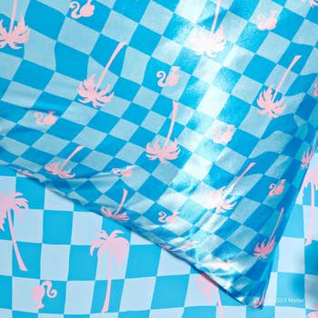 a malibu barbie satin pillowcase with blue checkered patterns and pink barbie outlines 