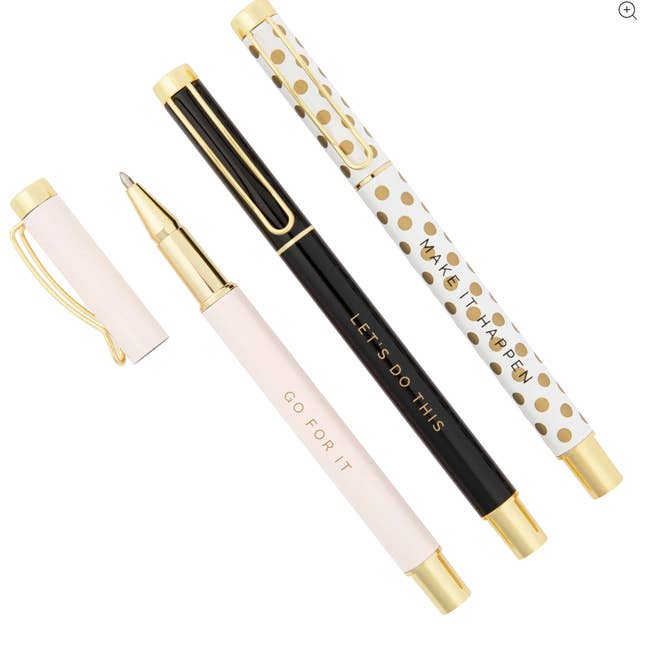A pastel pink, black, and gold and white polka dot pen, each with gold accents and a different inspirational message written on them 