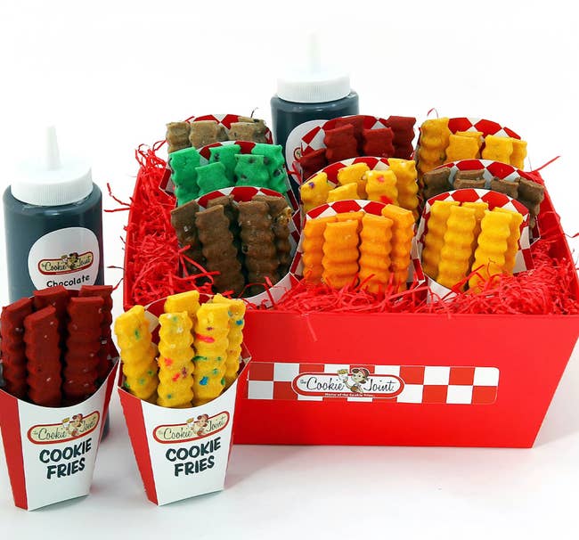 Assorted cooky fries successful cups with dipping sauces successful a checkered acquisition box, acceptable connected reddish decorative filler