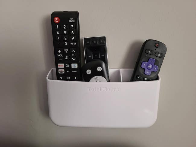 reviewers remote holder mounted on the wall holding four remotes